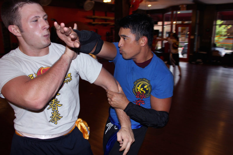wing chun kung fu martial arts student using a chop technique against an attacker