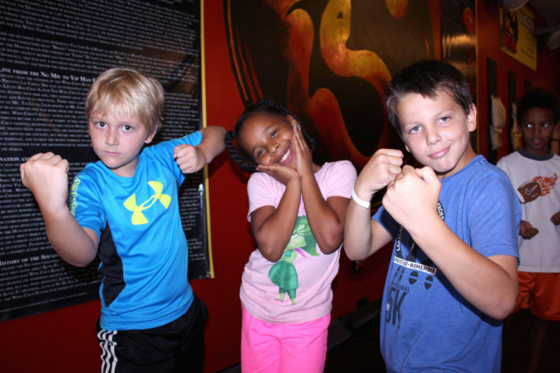 kids in kung fu poses making faces towards camera