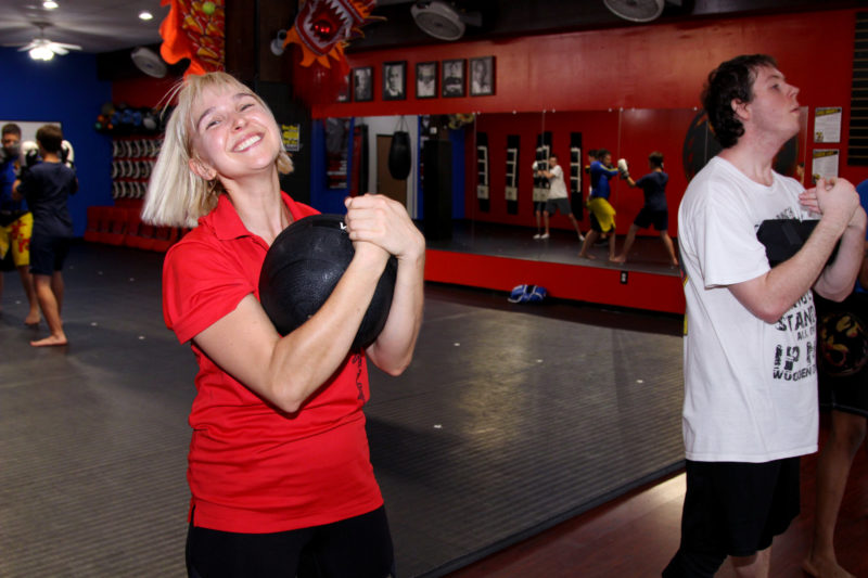 woman holding exercise ball in group fitness class
