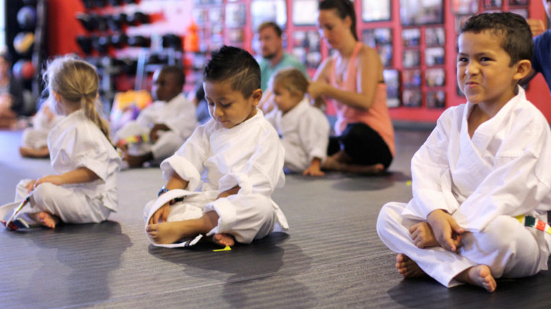 preschool children sitting at attention in martial arts uniform