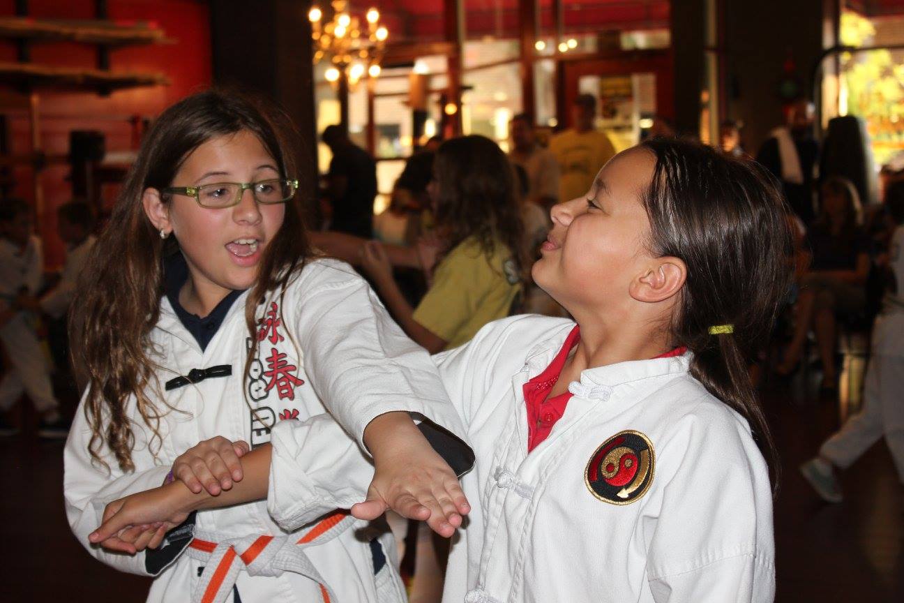 kids martial arts student practicing chopping technique on other student