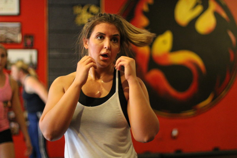 woman holding her fists up moving in lakeland kickboxing class