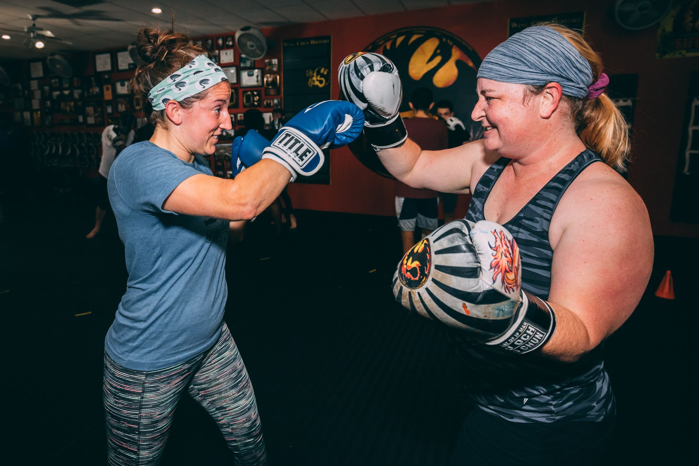 two women smiling wearing boxing gloves in kickboxing classes