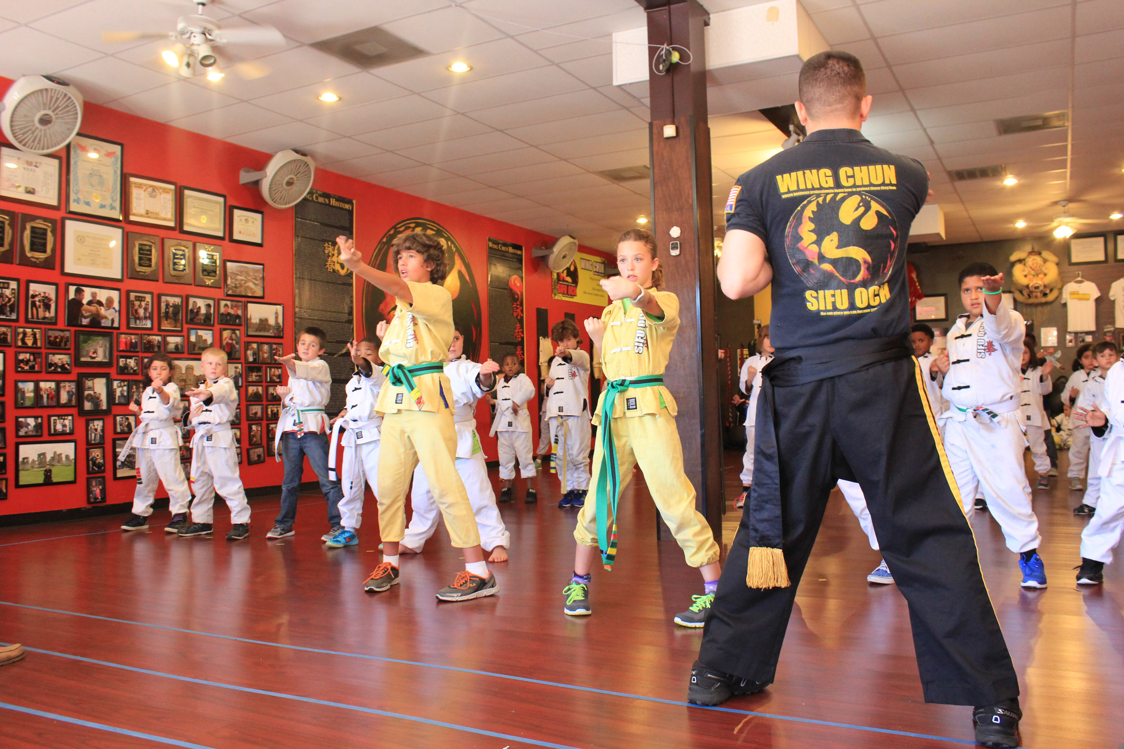 martial arts students lined up in uniform following wing chun instructor