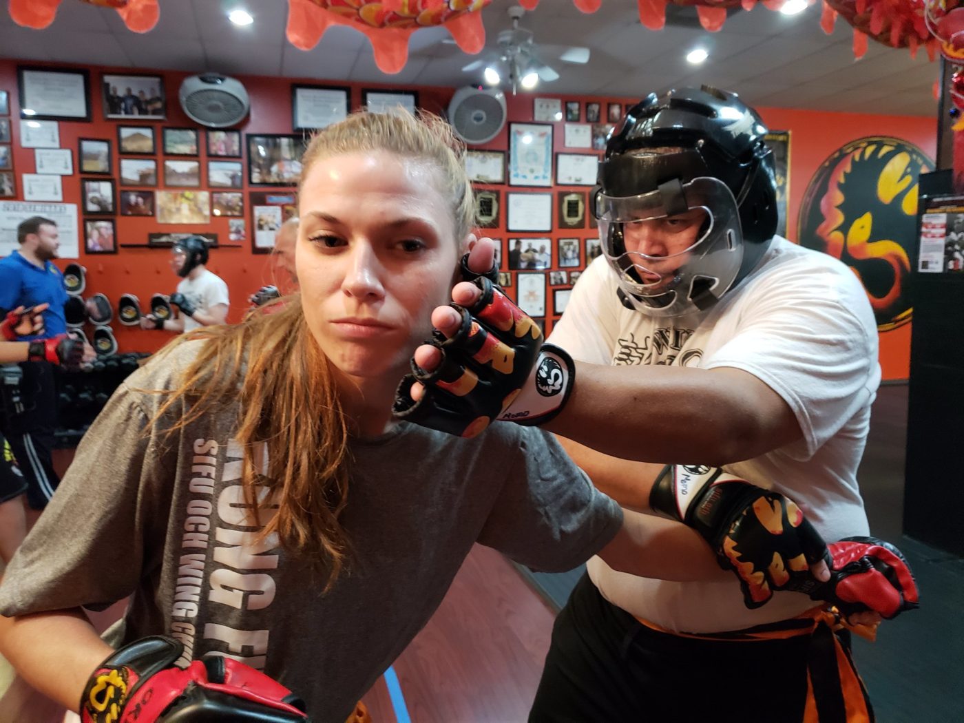 wing chun students in sparring gear practicing attacks in self defense classes