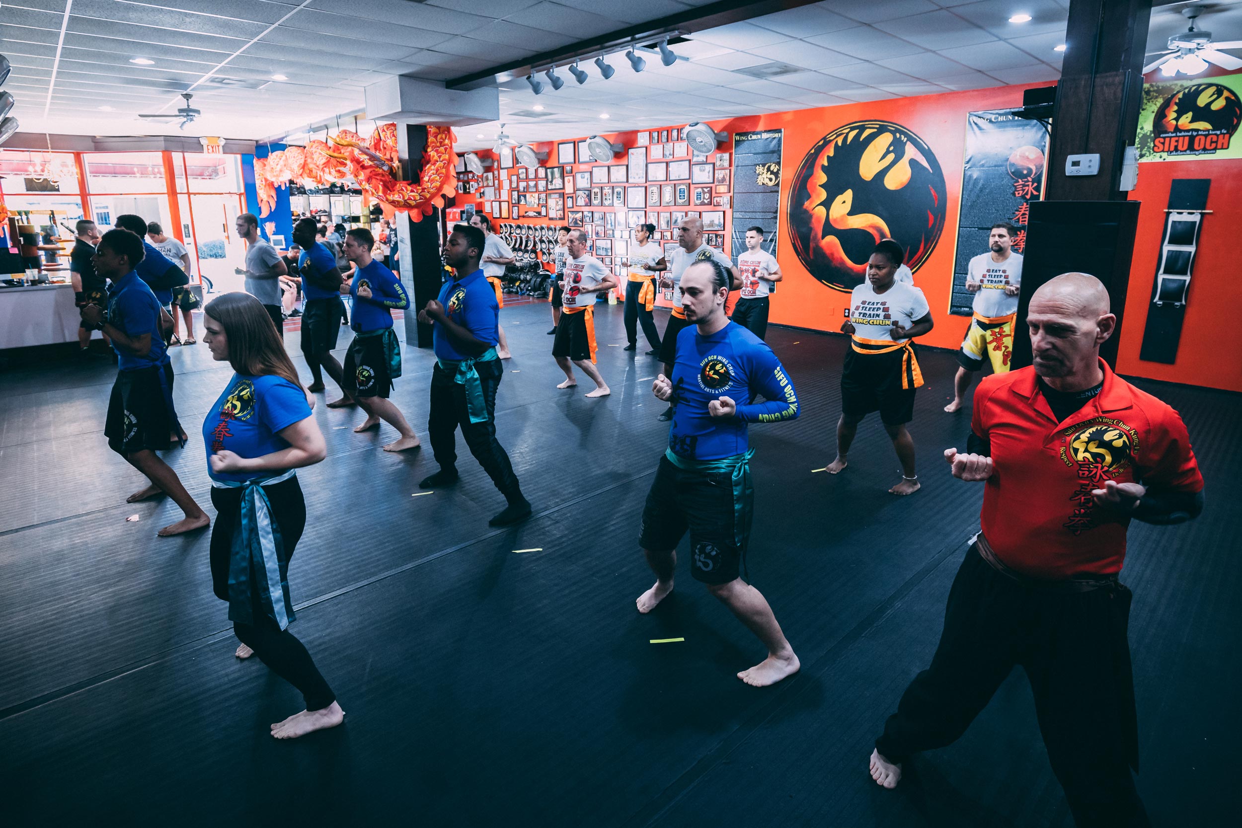 students lined up in martial arts studio doing wing chun kung fu first form self defense