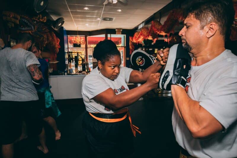 black woman in self defense wing chun martial arts class double punching forward
